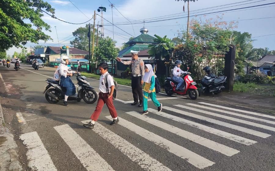 Wujud Kamseltibcar Lantas yang prima, Sat Lantas Polres BU Bantu Menyebrangkan Anak Sekolah